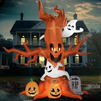 Inflatable Halloween tree with ghosts and pumpkins in front of a house.