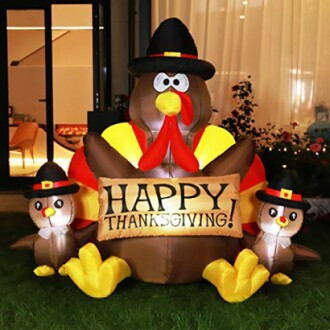 Inflatable Thanksgiving turkey decoration with a sign that reads 'Happy Thanksgiving'.